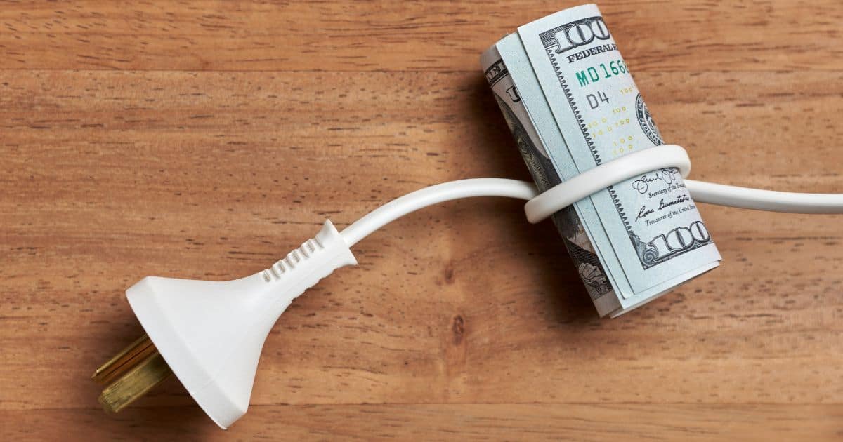 An electric cord with a roll of money wrapped up in it