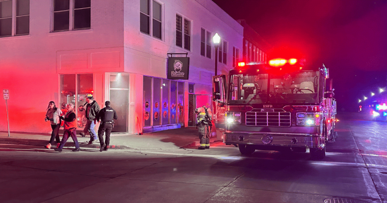 Pho House Vietnamese Noodle Bar with the Excelsior Springs Fire Department in front and firefighters walking on the corner