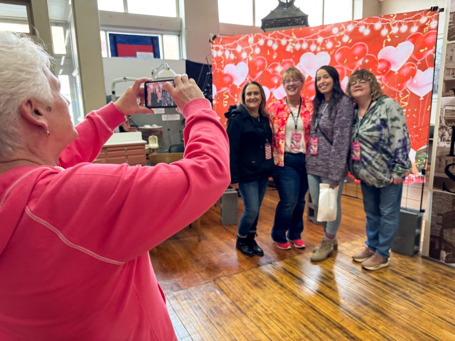 Deb Foster takes a photo of four women at the Excelsior Springs Museum during the Downtown Excelsior Partnership's Chocolate Tour