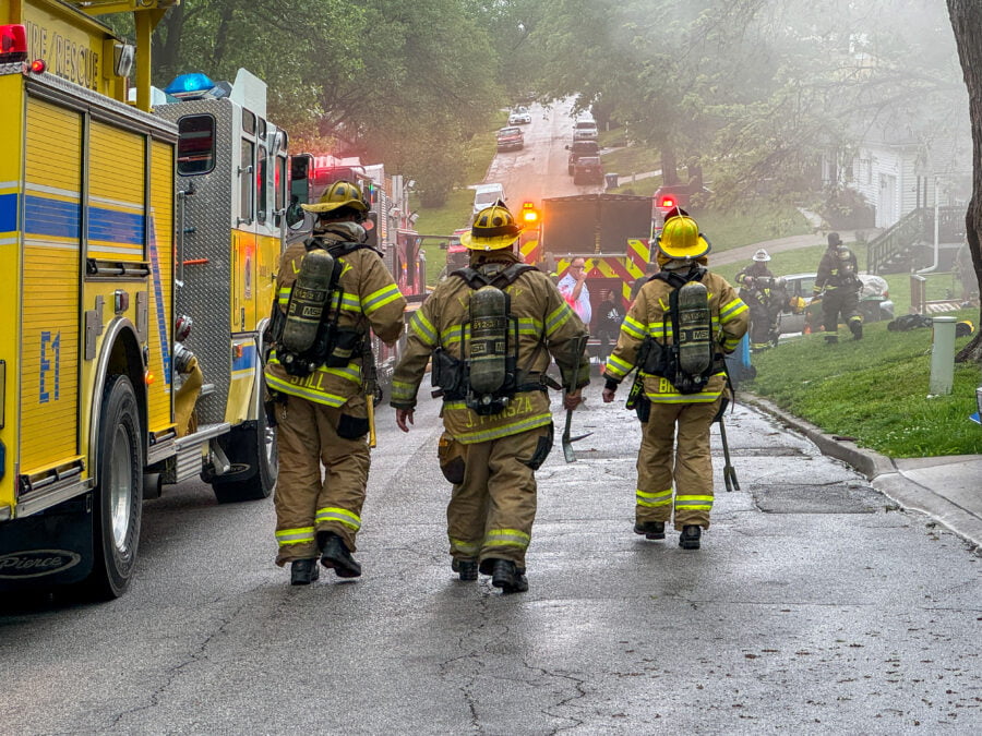 Excelsior Springs Firefighters walk together toward a home fire on Southview Drive