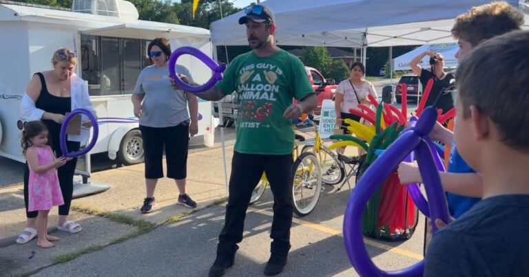 A Yellow Box of Magic demonstrates balloon animals during National Farmers Market Week