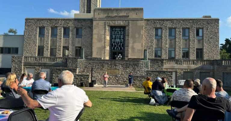 Hall of Waters lawn with people sitting in chairs at tables