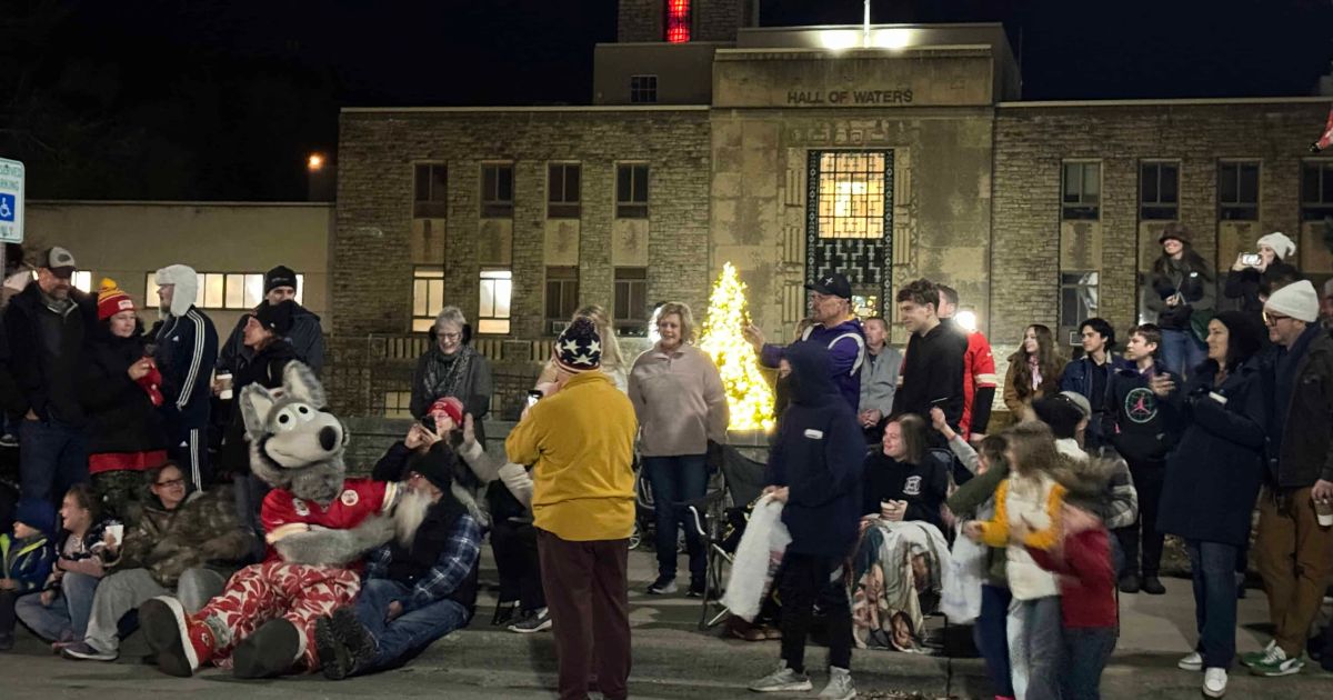 KC Wolf in a crowd in front of the Hall of Waters during the Lighted Christmas Parade