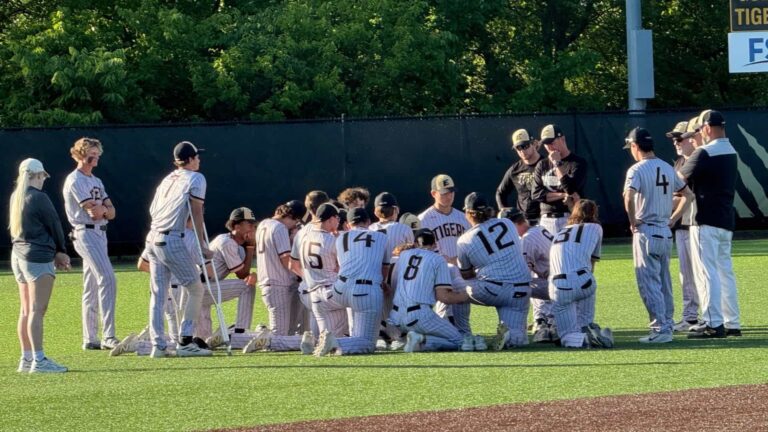 Tigers in a team huddle with Coach Holst leading after loss to Benton Cardinals.
